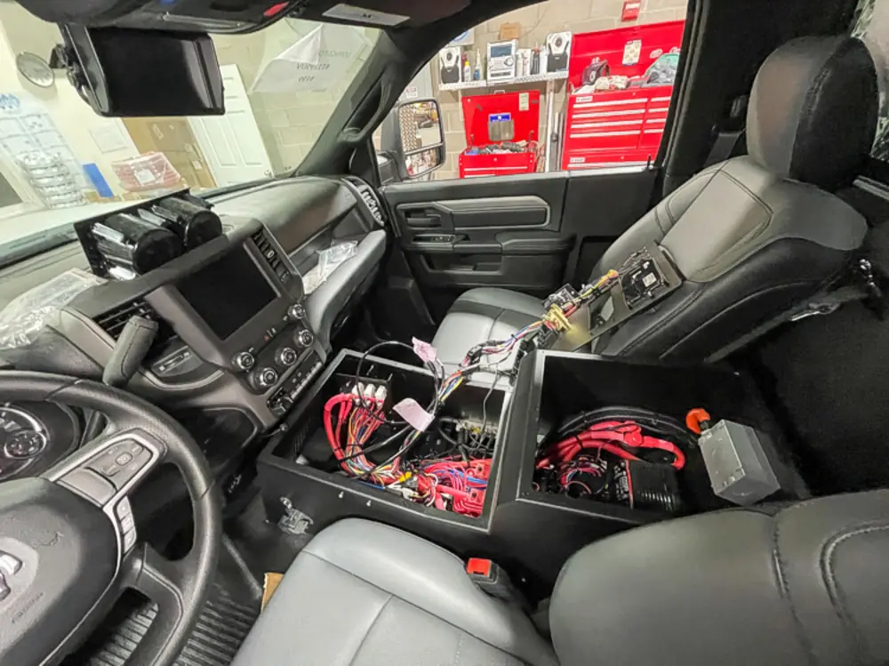 Exterior view of small fire truck showing cab, body compartments, and wheel/tire area.